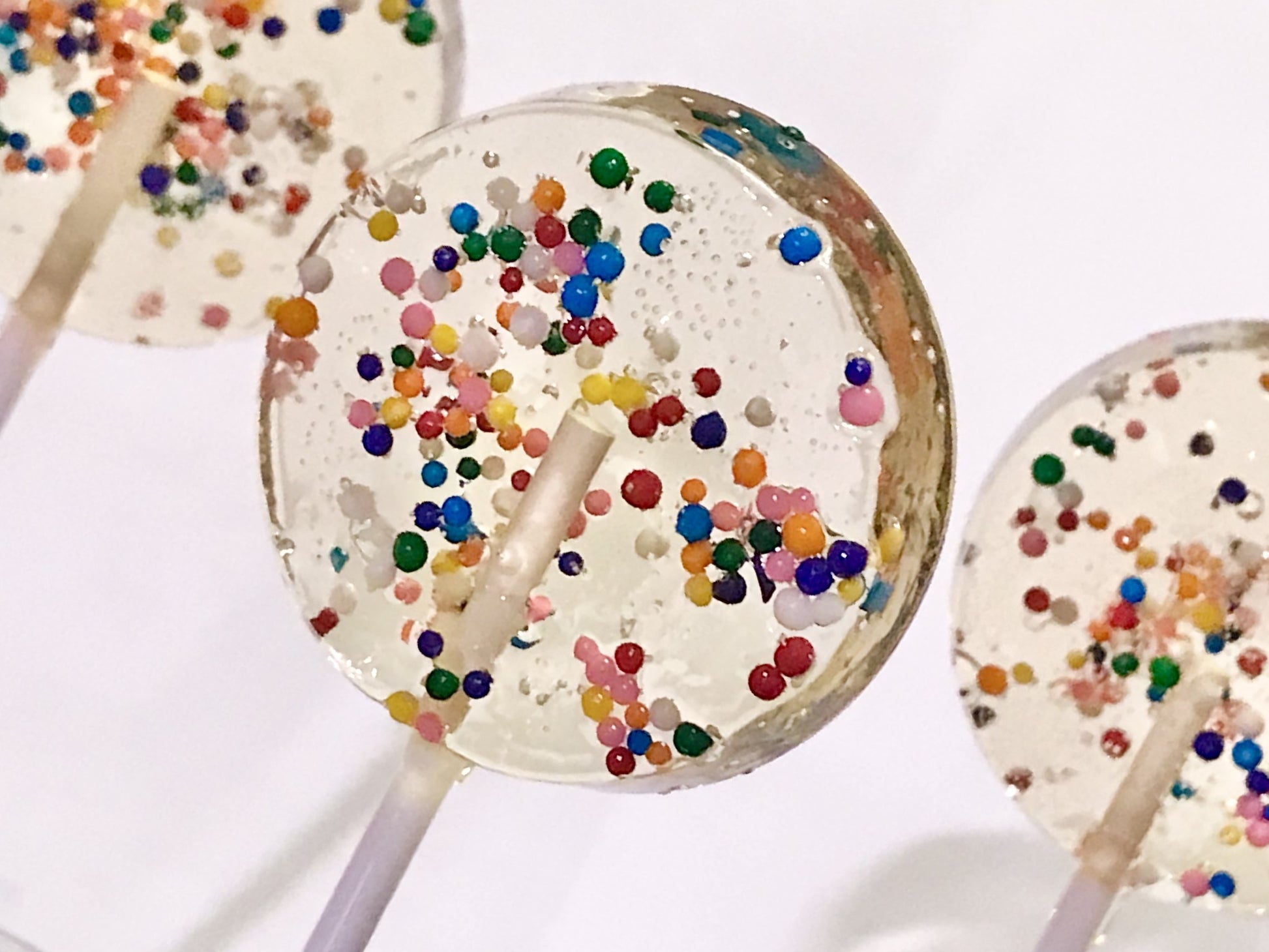 Set of 10 1.5" Lollipops filled with dye-free confetti sprinkles.